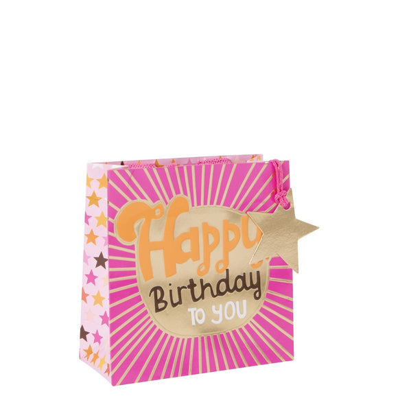 This petite gift bag is the perfect size for candles, mugs or jewellery. This small gift bag is decorated in shades of bright and pale pink, with a large gold starburst on the front of the bag, containing text that reads 