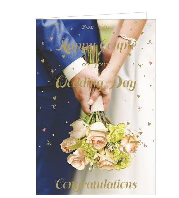 This wedding congratulations card is decorated with a close up of a bride and groom holding the bridal bouquet of champagne roses between them. Gold text on the front of the card reads 
