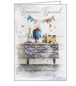 This birthday card for someone special is decorated with an illustration of a stylish sideboard cupboard topped with a bottle of champagne, a Birthday cake, presents and bunting. Metallic text on the front of the card reads "For Someone Special...Here's to You!"