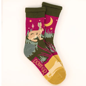 This pair of mens socks from fashion brand Powder are decorated with a scene of a hare in a field. These socks are knitted in a retro-colour palette of yellow, green and pink.