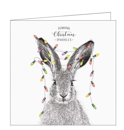 This Christmas card from Pigment Production's Life in Pencil card range is decorated with a black and white sketch of a hare, with a line of coloured fairylights draped over its ears. The caption on the front of the card reads 