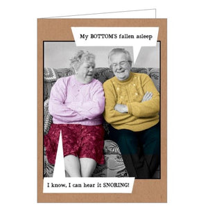 This funny blank card features a vintage, colourised photograph otwo older people sitting on a sofa. One says "My bottom's fallen asleep" and the other responds with "I know, I can hear it snoring!"