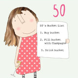 This 50th birthday card features one of Rosie's unmistakably witty and charming illustrations of showing a woman in a pink dress holding a glass of champagne and a to-do list. The list reads "50th bucket list: 1) Buy bucket 2) Fill bucket with champagne 3) Drink bucket".