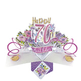 A spectacular pop-up 3D keepsake 70th birthday card, that opens to unleash pink streamers, delicate flowers and text that reads "Happy 70th Birthday".