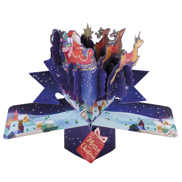 This pop-up 3D keepsake card opens out to show Father Christmas in his sleigh, pulled by reindeer, flying through the night's sky over a sleeping village.