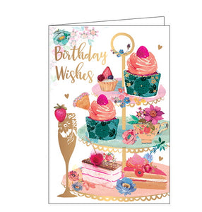This birthday card features a 3 tier cake stand filled with lots different types of cake and flowers next to a golden glass of Prosecco. Gold text on the front of the card reads "Birthday Wishes".