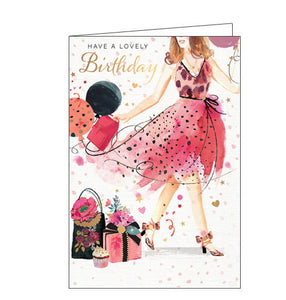 This birthday card is decorated with an illustration of a fashionable young lady wearing a pink party dress, covered with gold confetti. The girl carries a bunch of balloons as she walks past a pile of beautifully wrapped birthday gifts. The text on the front of the card reads "Have a Lovely Birthday". 